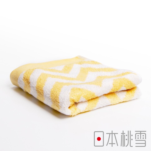 黃白色相間的鋸齒狀圖案今治毛巾，材質為柔軟吸水的棉質，對折整齊擺放於白色背景上。