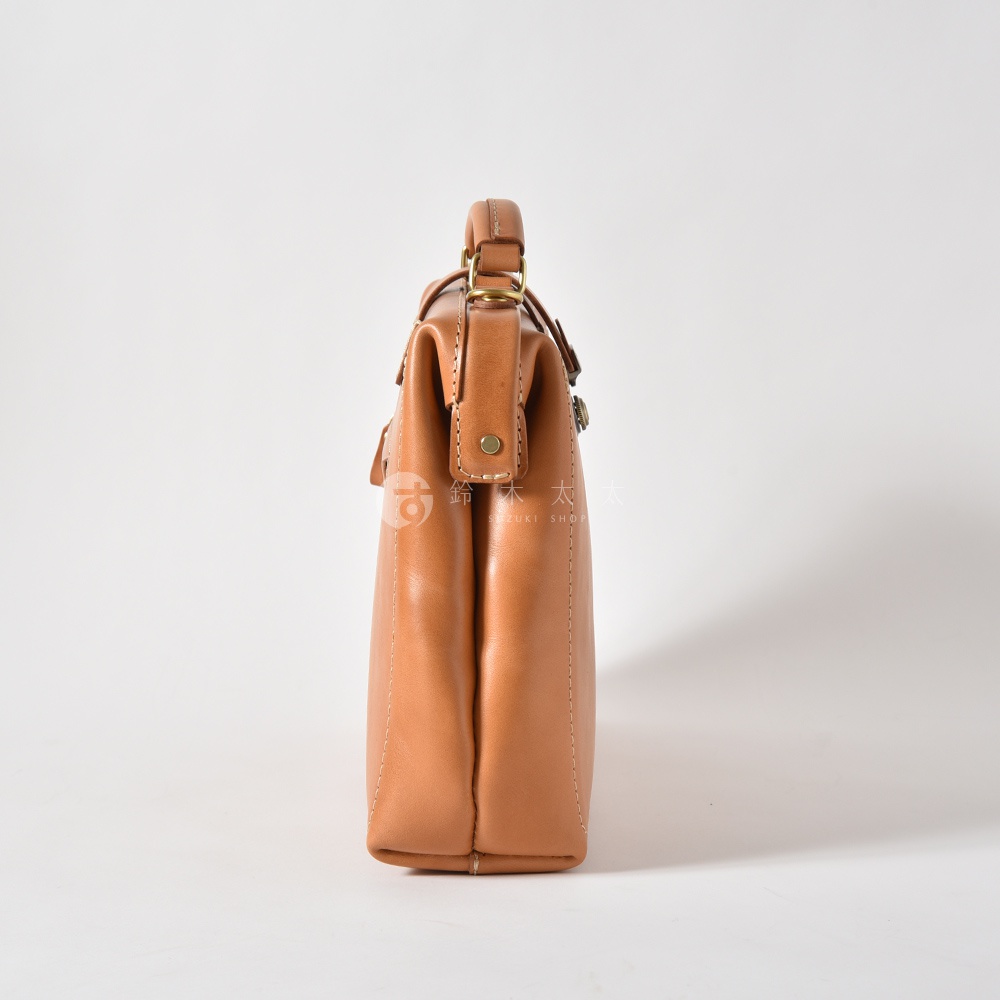 職人手作皮革軟式杜勒斯三用背包，淺棕色，側邊視角，展示包身線條與金色五金件。