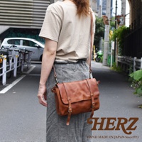 職人手作皮革復古郵差包，採用鞣製皮革製成，散發自然光澤，配有可調式肩帶和金屬釦環。