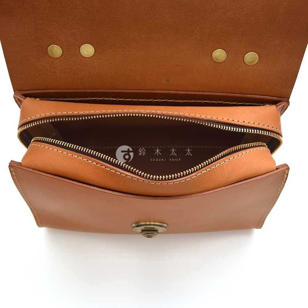 日本HERZ品牌皮革單肩包，打開的拉鍊內部有品牌標誌，頂部有兩顆金屬卯釘。