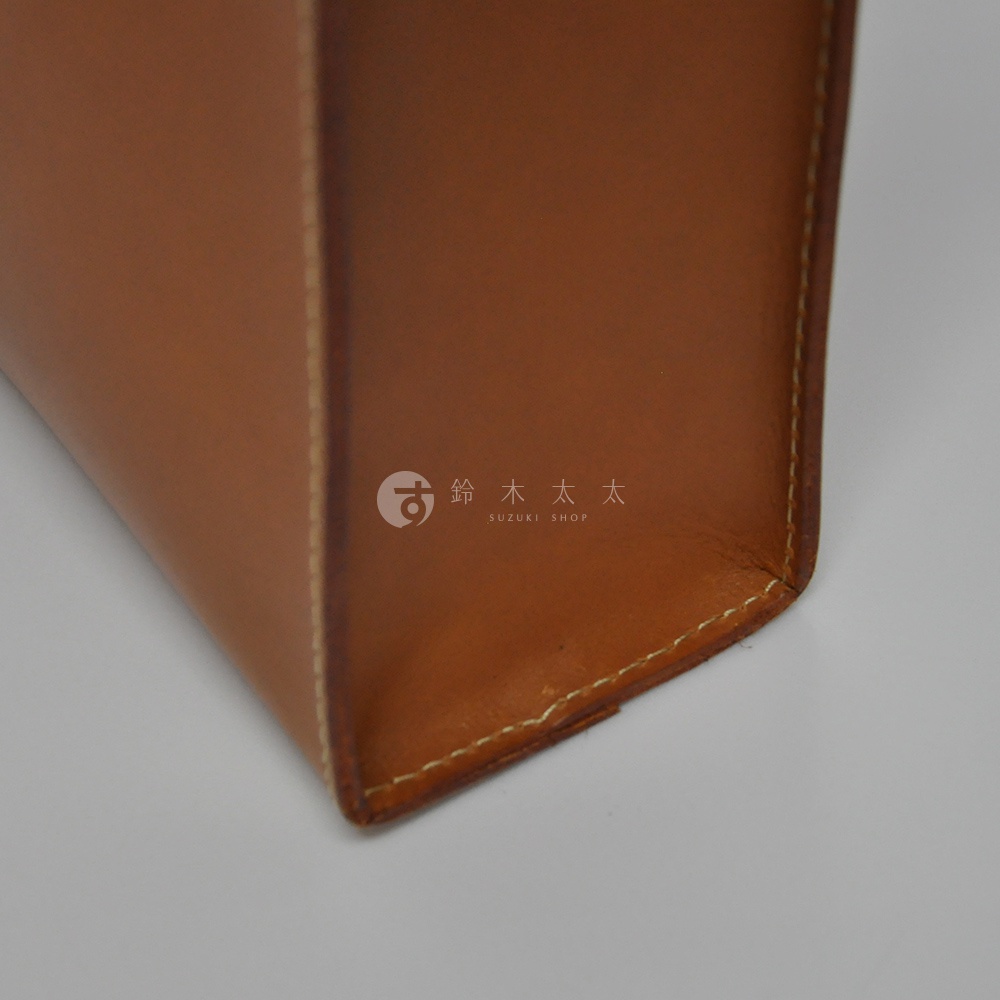 職人手作皮革直式托特包 T-44 L，展示焦糖棕色澤，細緻車縫線展現皮革質感。