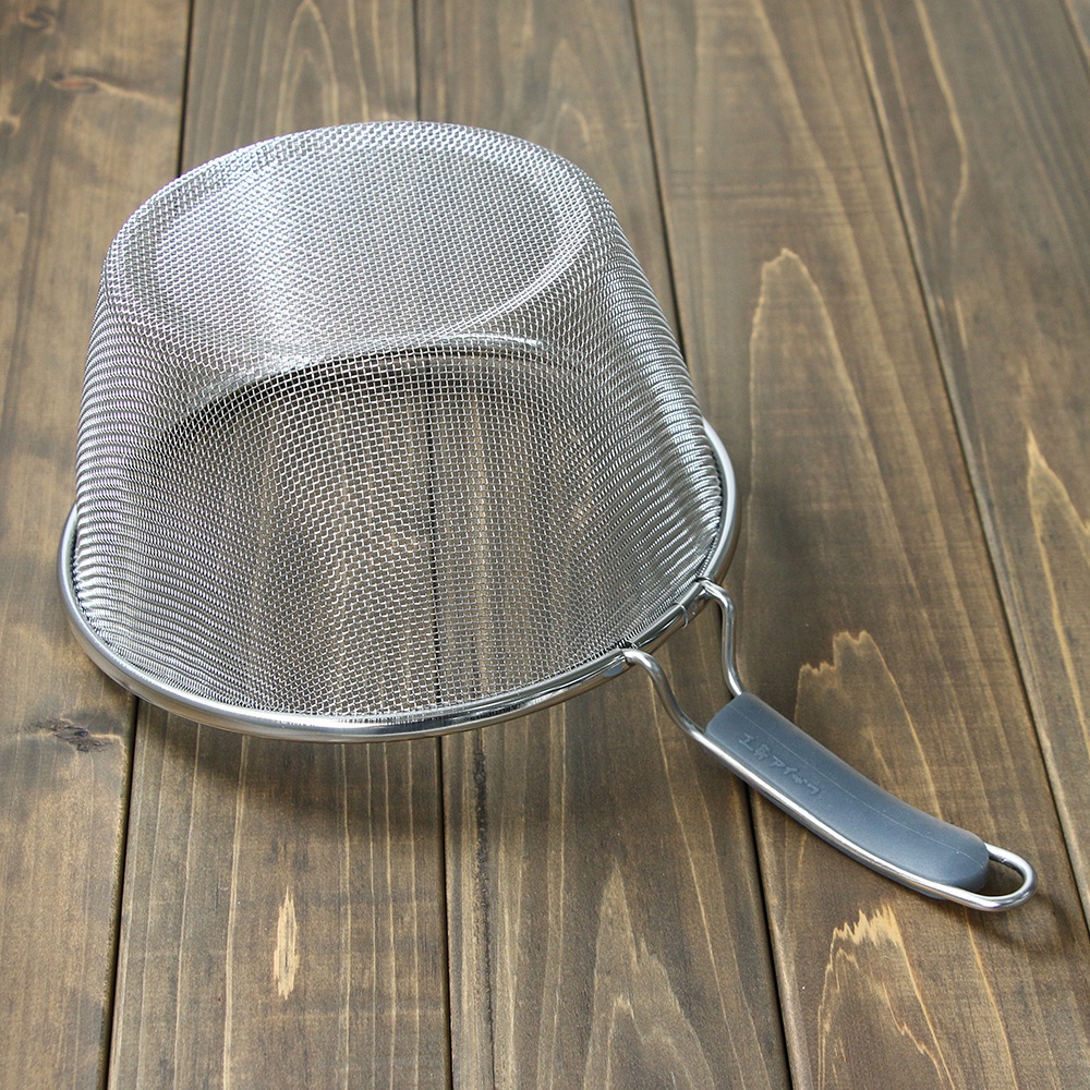 一個 20 公分的不鏽鋼濾網，帶有灰色的矽膠握柄，置於木紋背景上。