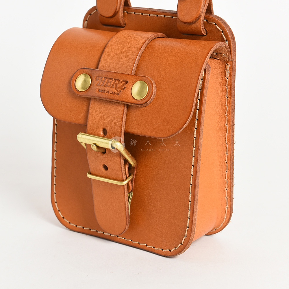 職人手作皮革經典腰袋，採用棕色皮革，設有翻蓋、皮帶扣及品牌壓紋，手工縫線清晰可見。