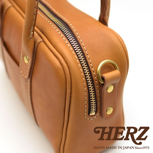 HERZ 職人手作皮革兩用迷你波士頓包，近拍拉鍊及金色五金細節，底部有HERZ LOGO及HAND MADE IN JAPAN Since1973字樣
