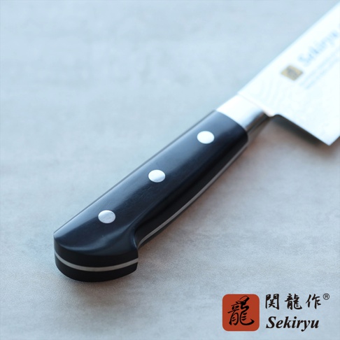 VG10不鏽鋼33層大馬士革三德刀，黑色握柄，設有三個銀色鉚釘，刀柄與刀身之間有金屬鑲嵌。