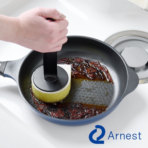 Arnest直角鍋專用不沾手防刮清潔海綿用於清潔煎鍋中的食物殘渣，海綿一側為黃色，另一側為白色。