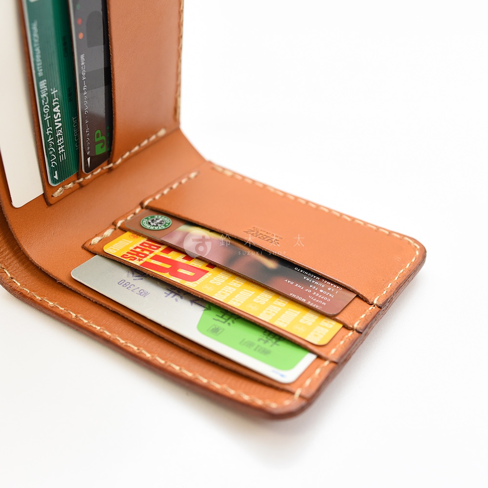 職人手作皮革二折橫式卡片紙鈔小短夾，展示卡槽內有多張信用卡及卡片，皮革顏色為棕褐色，縫線細緻。