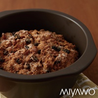 深灰色陶土湯鍋，內盛裝著有葡萄乾的烘焙食品，表面撒有細砂糖。