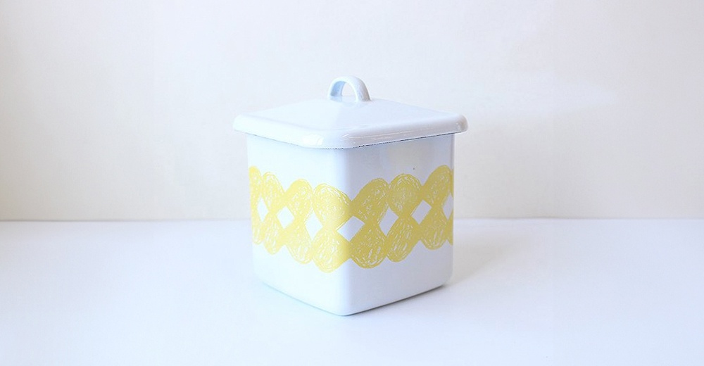 kukka 琺瑯方形收納盒，白色琺瑯材質，帶有淺藍色邊緣，盒身飾有黃色連續菱形網狀圖案，頂部有提把。