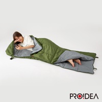 綠色兩用睡袋，內襯為灰色，睡袋展開呈現，一位女性躺在其中使用手機。