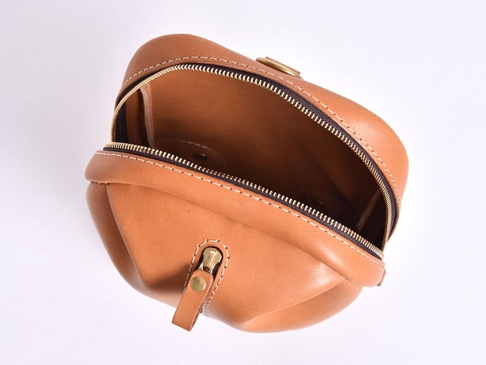 職人手作皮革立體運動斜背包，呈現溫潤的棕褐色，由高品質皮革製成，搭配金色拉鍊與縫線，展現精緻工藝，包款立體飽滿，適合運動與日常使用。