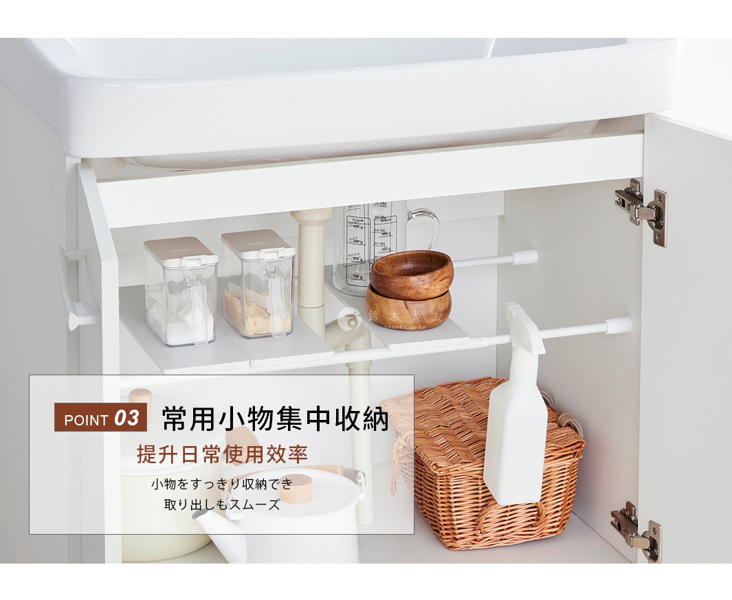 這張圖片展示了在洗手台下方櫃子中使用平安伸銅伸縮桿專用置物板的收納情境。櫃內透過伸縮桿搭配白色置物層板，在原本的空間中創造出額外的置物平台。層板上整齊放置了透明調味罐與木質碗具，右側則懸掛了一瓶清潔噴霧，下方收納籃與水壺也井然有序。畫面左側文字強調此設計能集中收納常用小物，有效提升日常使用效率。