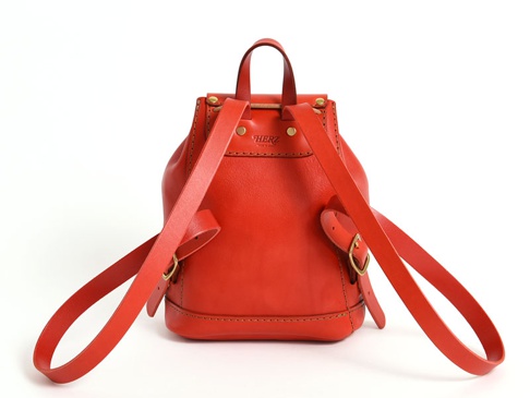 職人手作紅色皮革迷你後背包，採用圓潤桶狀設計，搭配可調式皮革肩帶和金色扣環，展現經典復古風格。