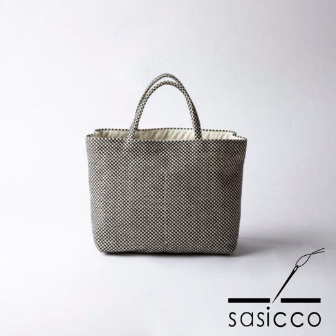 一款黑白格紋三河木綿刺子織托特包，配有米色內襯和提把。