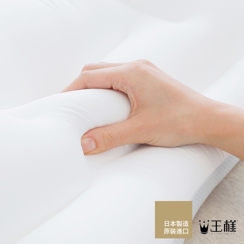 手輕壓白色天絲 TENCEL 枕套包裹的枕頭，展現枕頭柔軟的支撐性。