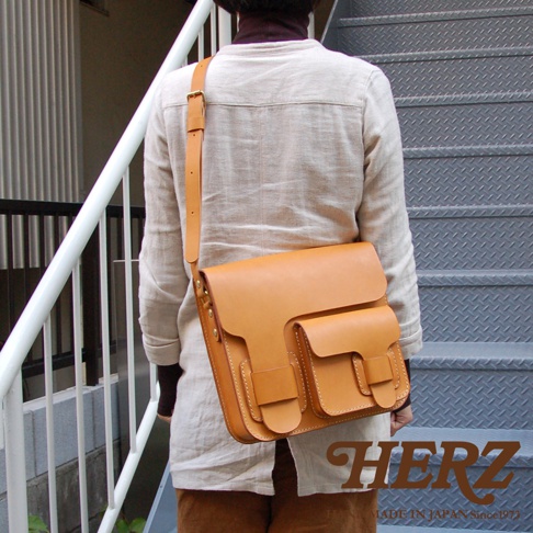 職人手作皮革經典厚實單肩包，呈現自然原色皮革質感，設有兩個立體前袋，搭配可調式肩帶，適合日常攜帶。