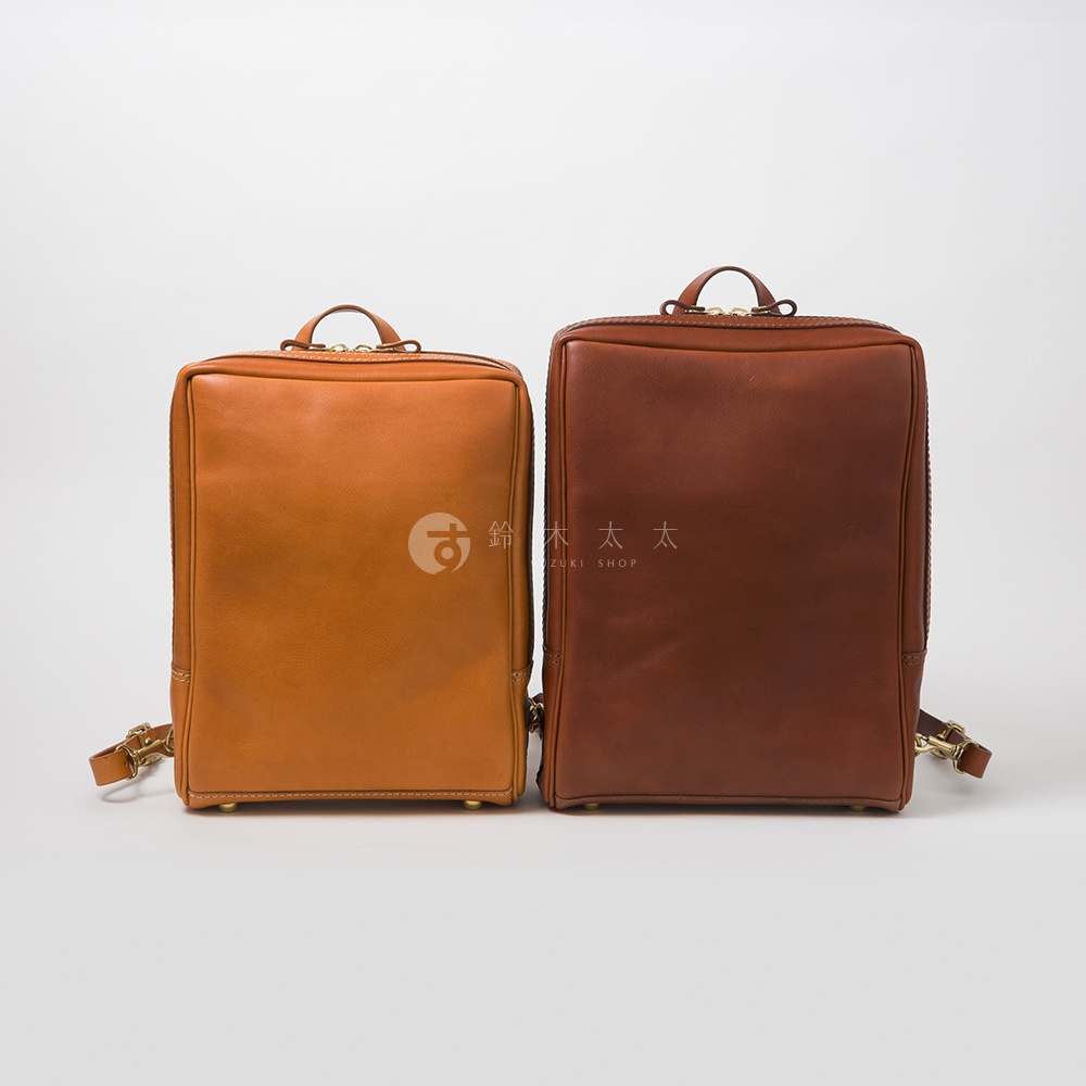 兩款職人手作皮革軟皮商務後背包，一款為淺棕色，另一款為深棕色，皆採用柔軟皮革材質，設計簡潔實用。