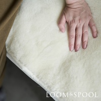 單人美麗諾羊毛厚感保暖墊，奶油白色，觸感柔軟蓬鬆，展示了其保暖材質的質感。