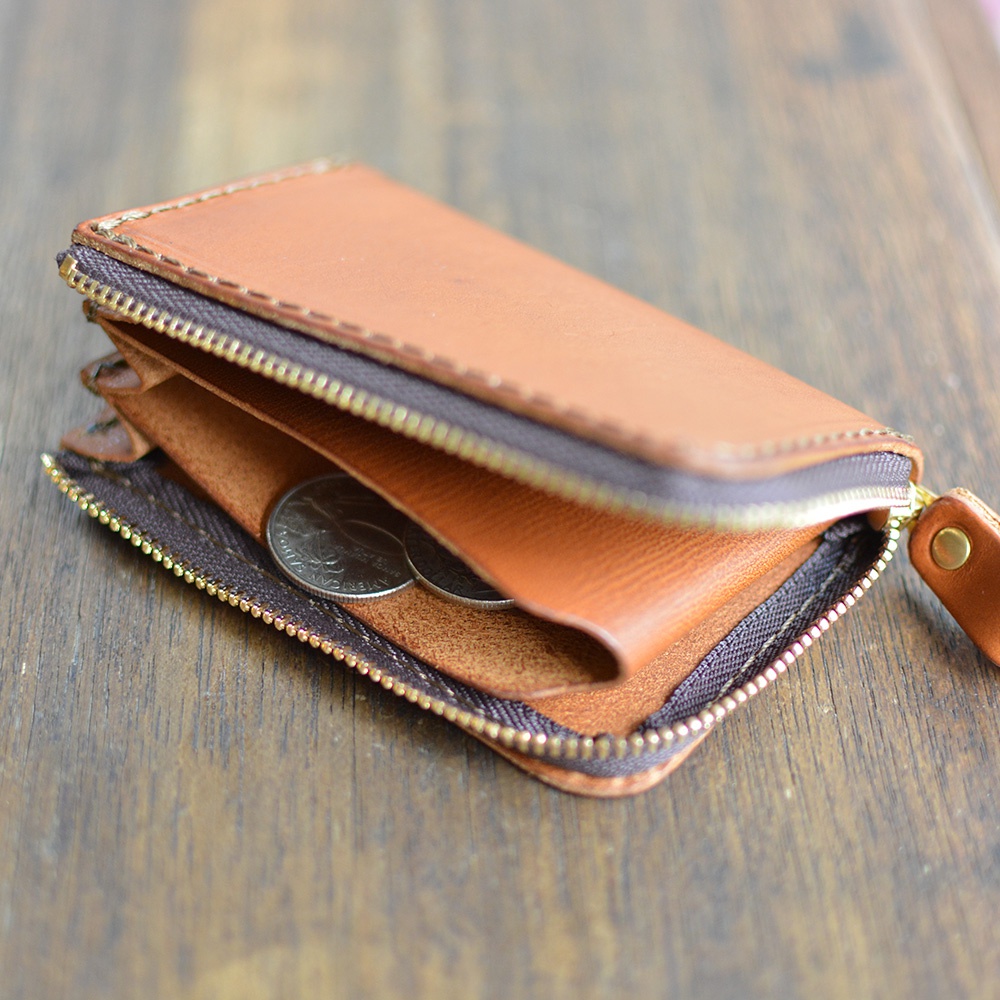 職人手作皮革Organ口袋拉鍊短夾，淺棕色，展示皮革紋理，拉鍊開口露出內部空間及幾枚硬幣，搭配同色皮革拉環。
