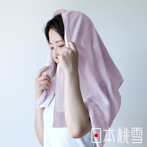 一位女性頭上蓋著一條淺紫色、材質厚實的迷你浴巾，浴巾上有著明顯的織紋。