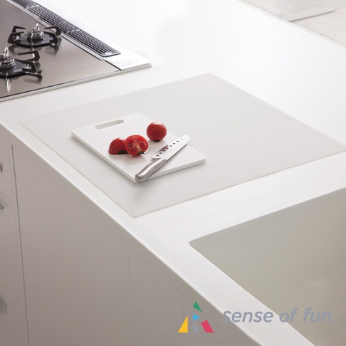 白色耐高溫料理台保護墊，鋪設在白色料理台上，上方有一個白色砧板，上面放著兩顆番茄和一把銀色刀具。