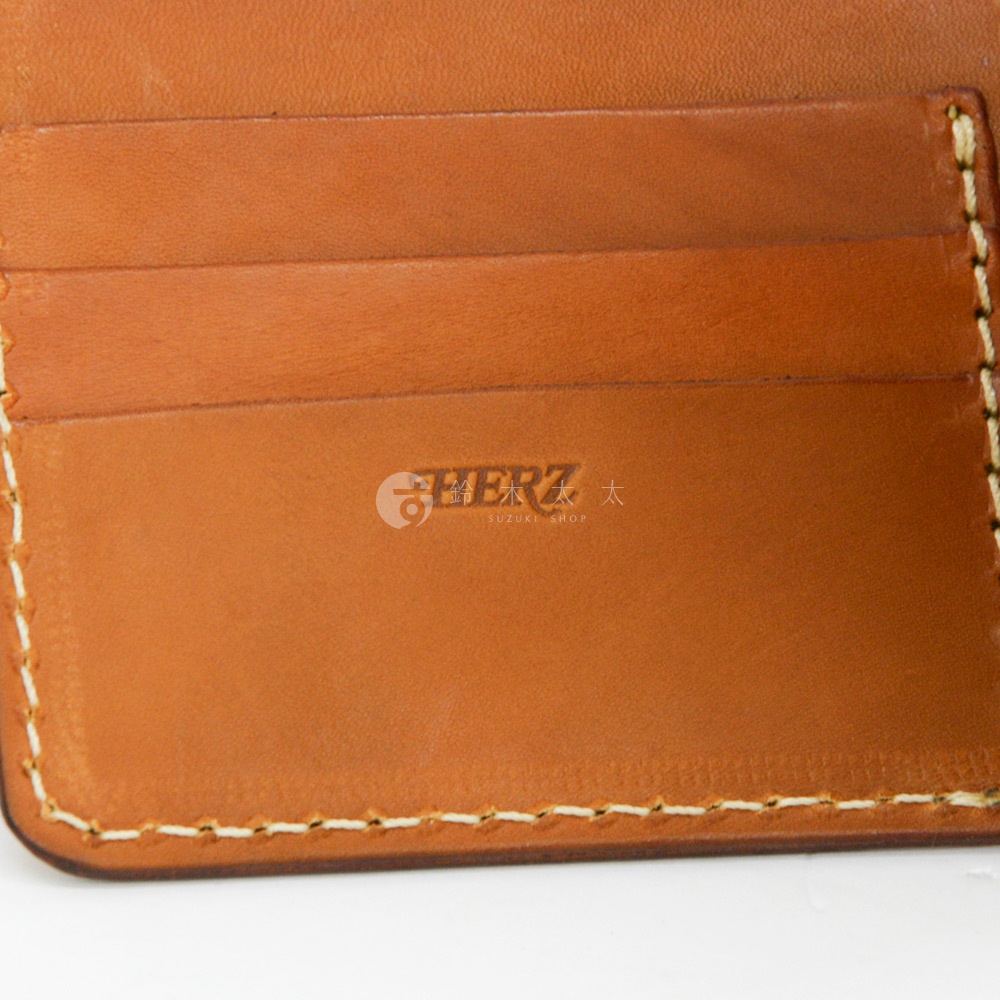 職人手作皮革二折橫式卡片紙鈔小短夾，展示內裡卡槽與品牌標誌，皮革顏色為棕色，縫線為白色。