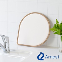 淚滴型抗菌料理砧板，米白色表面，帶有淺棕色邊框，置於廚房水槽旁。