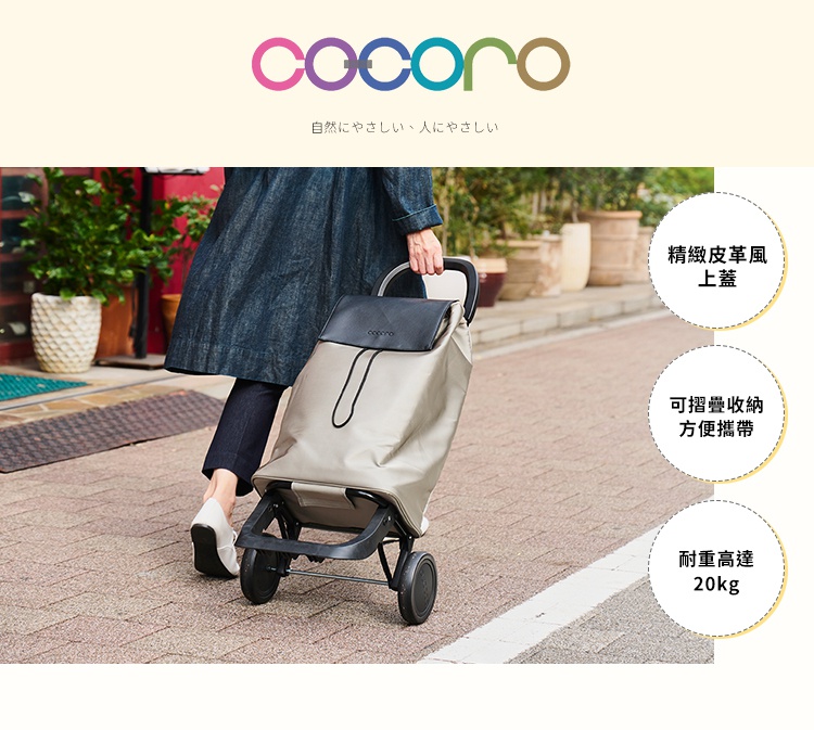 一位女性走在街道上，手中拖著一台 COCORO Luce 摩登風摺疊購物車，該購物車為灰色包身搭配黑色皮革質感上蓋，強調具有耐重二十公斤、可摺疊收納方便攜帶以及精緻皮革風上蓋的設計特色。