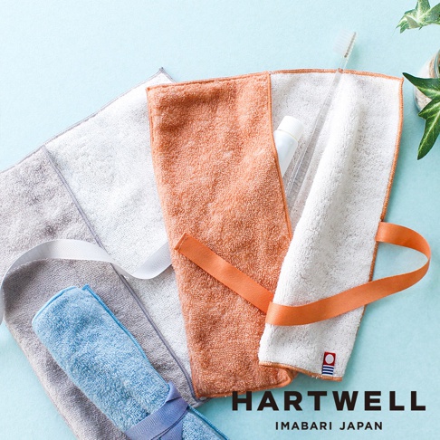 三款今治毛巾牙刷收納袋，分別為淺灰、橘色和白色，皆為速乾材質，橘色及白色款內含牙刷與牙膏，並有織帶方便攜帶。