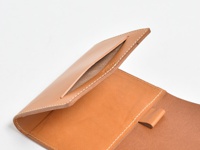職人手作皮革A6記事本書套，淺棕色皮革，內側有插槽與固定帶，白色車縫線。