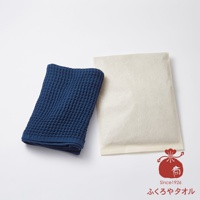 深藍色格紋毛巾與米白色包裝紙並列，下方有紅色印章圖案及日文文字。