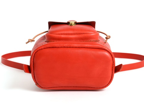 職人手作皮革經典迷你後背包，鮮紅色皮革，圓潤的底部，抽繩束口設計，配有金屬扣環的翻蓋，以及一對細長的皮革背帶。