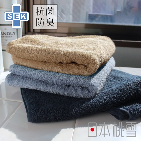 SEK抗菌防臭運動大毛巾，疊放展示，由上至下顏色為卡其色、淺藍色、深藍色。毛巾質感柔軟，材質應為棉質。
