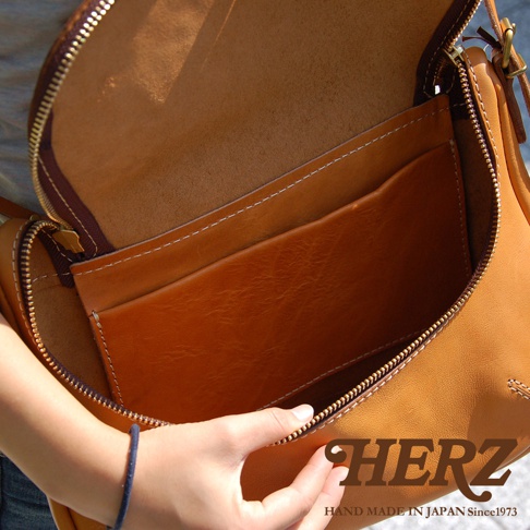 HERZ 職人手作皮革大容量馬鞍包 CK-150，展示其內部皮革細節，並印有「HERZ HAND MADE IN JAPAN Since1973」字樣。