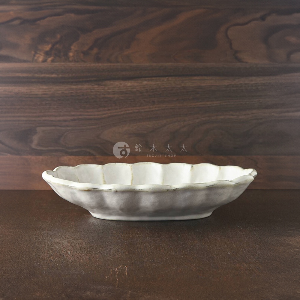 小兵 六魯粉引花型橢圓料理盤，28公分，白色陶瓷，帶有粉引釉色和自然的邊緣紋理，造型為帶有花瓣狀邊緣的橢圓形。