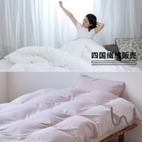 床上鋪著粉色床單，上面有睡袋，旁邊還有枕頭。