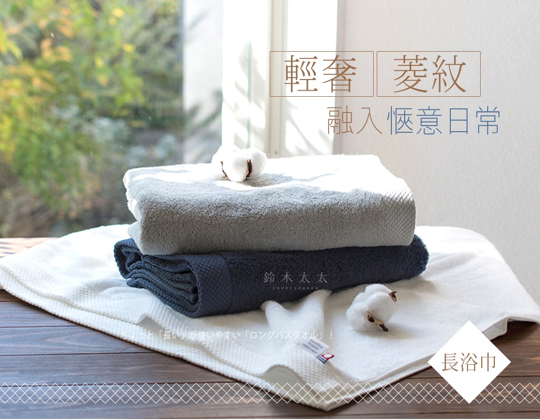 三條今治純棉長浴巾堆疊，顏色由上至下為淺灰、深藍、白色，均帶有菱紋織法。其中一條白色浴巾上放有一團棉花，另一條深藍色浴巾上有品牌日文標示。
