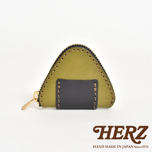日本HERZ職人手作皮革三角飯糰造型零錢包，以橄欖綠色皮革為主體，搭配深色皮革細節與金屬拉鍊，呈現獨特的三角飯糰外觀，右下角印有HERZ品牌標誌。