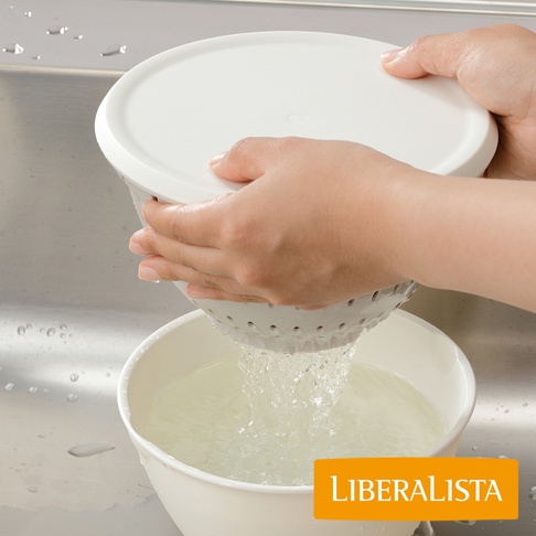 LIBERALISTA 標誌旁，一隻手正將白色瀝水籃從水槽上方提起，籃內的水正朝下方白色碗中傾倒。