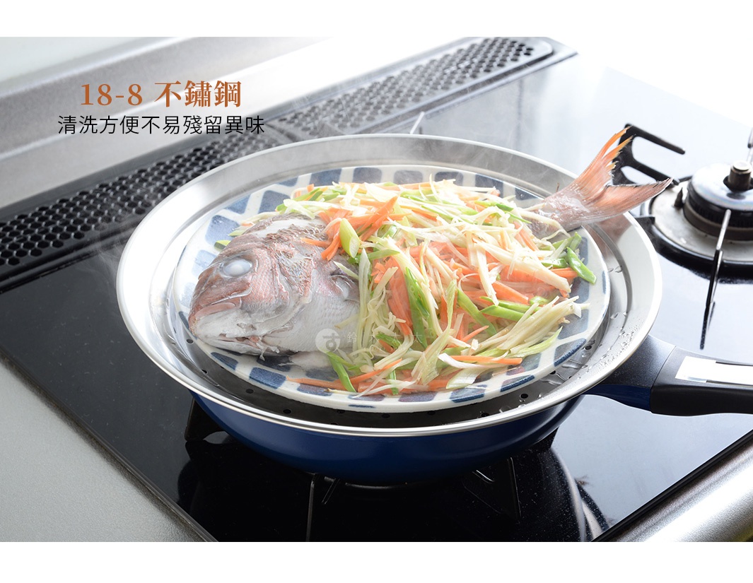 一個不鏽鋼蒸盤，上面放著一條鋪滿切絲蔬菜（如高麗菜、紅蘿蔔、蔥段）的魚，蒸盤置於藍色鍋具中，鍋具放在爐灶上。
