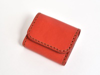 橘紅色皮革雙折收納零錢包，手工縫製，簡約設計。