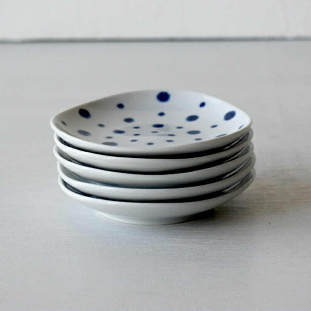一疊波佐見燒白色陶瓷醬料碟，碟面印有藍色圓點紋，碟邊緣為不規則的圓弧形狀。