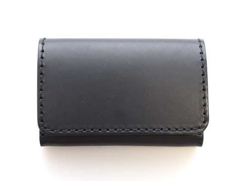 黑色皮革名片夾，有壓扣設計，邊緣縫線整齊。