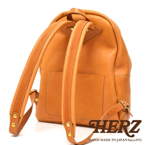 職人手作皮革休閒風後背包 R-93，採用淺棕色天然皮革製成，質感柔軟，設計簡約。背包設有外袋，肩帶可調節，並以車縫線和铆釘加固，整體呈現經典耐用的風格。