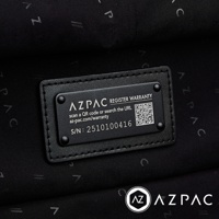 AZPAC 黑色行李箱上的註冊保固標籤，包含 QR 碼、網址 az-pac.com/warranty 及序號 S/N: 2510100416