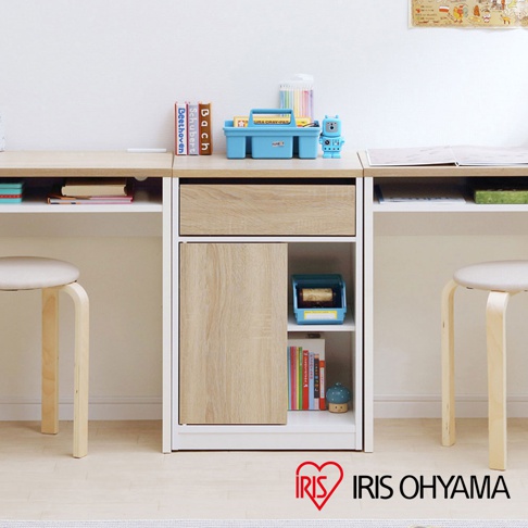 白色框架的木質抽屜收納櫃，配有淺木紋的抽屜和門板，下方為開放式層架，展示有書籍和收納盒。