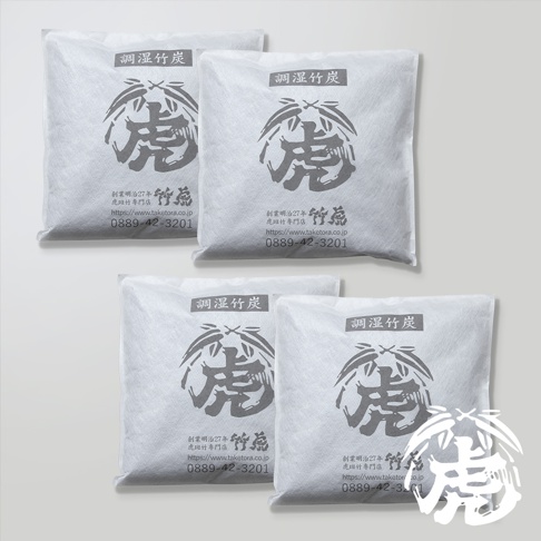 四件白色不織布包裝的調濕孟宗竹炭，每包中央有黑色虎形圖案與竹葉，下方印有日文文字、網址及電話號碼。