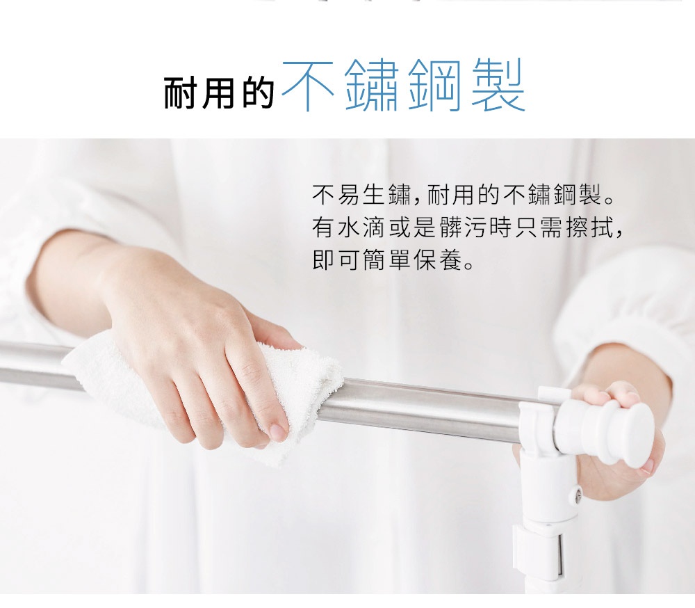 一隻手正用白色毛巾擦拭雙桿不鏽鋼曬衣架的銀色金屬桿。