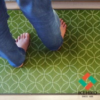 榻榻米廚房地墊，綠色織紋，帶有白色圓形幾何圖案，兩隻赤腳踩在上面。