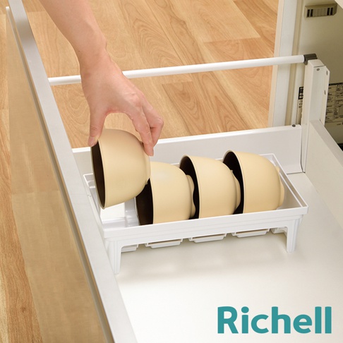 一位手正在將一個淺棕色的碗放入白色餐碗收納架中，收納架內已放置三個相同的碗。